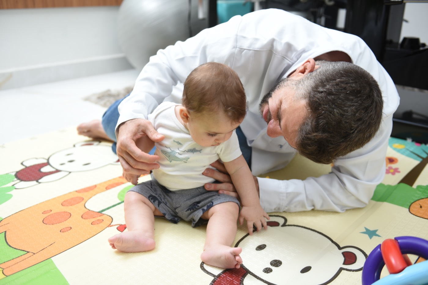 Dr. Diego atendendo um bebê no tapete